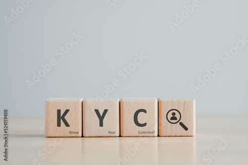 KYC on wooden cubes. know your customer with magnifying glass. Business verifying the identity of its clients concept photo
