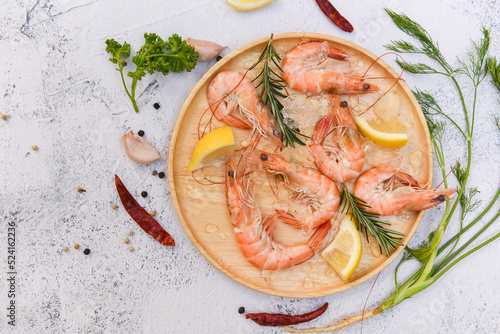 Fresh shrimps on wooden palte with lemon spices and herbs, boiled shrimp prawns cooking food in the seafood restaurant photo