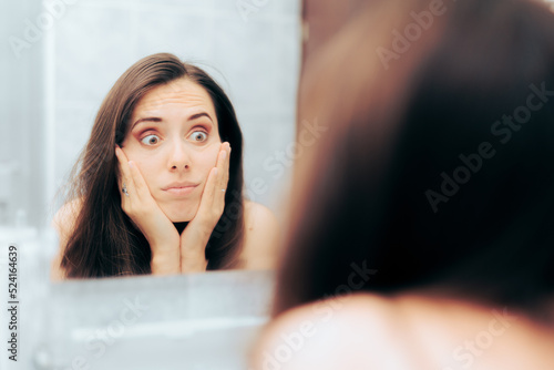 Worried Woman in her 30s Checking herself in the Mirror. Person suffering from body dysmorphic disorder overanalyzing her image
 photo