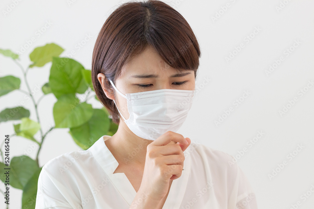 マスクをして咳をする女性