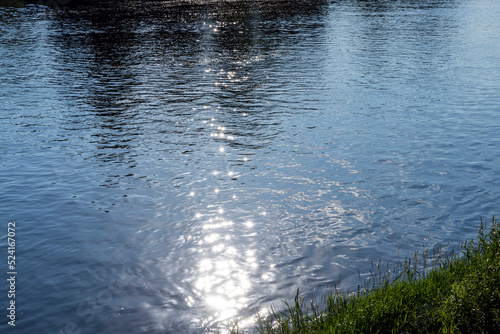 Sun glare in the water of the river with waves