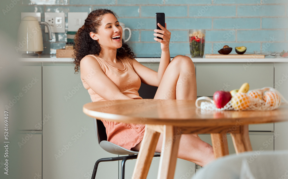 Woman browsing on phone reading social media post with an online app while relaxing in the kitchen. Female relaxing, smiling and enjoying a funny post, video or meme on the internet in the morning Woman browsing on phone reading social media post with an online app while relaxing in the kitchen. Female relaxing, smiling and enjoying a funny post, video or meme on the internet in the morning