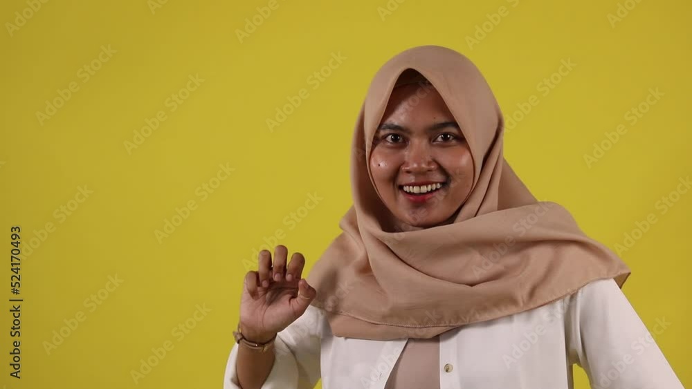 Fashion portrait of young beautiful asian muslim woman with wearing hijab isolated on yellow background Fashion portrait of young beautiful asian muslim woman with wearing hijab isolated on yellow background