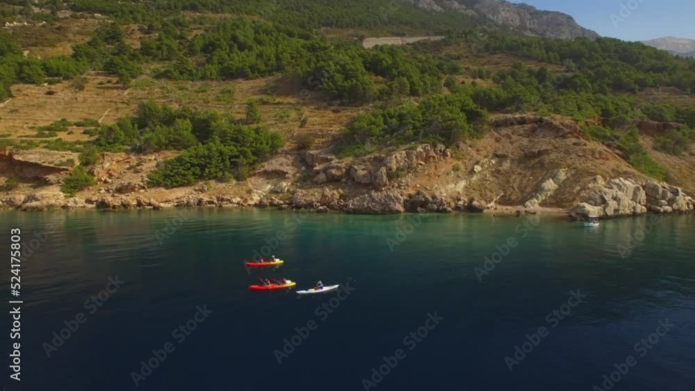 People kayaking in the sea, green nature and rocks. People kayaking in the sea, green nature and rocks.