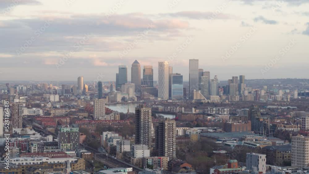 Establishing Aerial shot over London Limehouse district on a bright misty day. Iconic Canary Wharf skyline seen along the River Thames in the distance. Establishing Aerial shot over London Limehouse district on a bright misty day. Iconic Canary Wharf skyline seen along the River Thames in the distance.