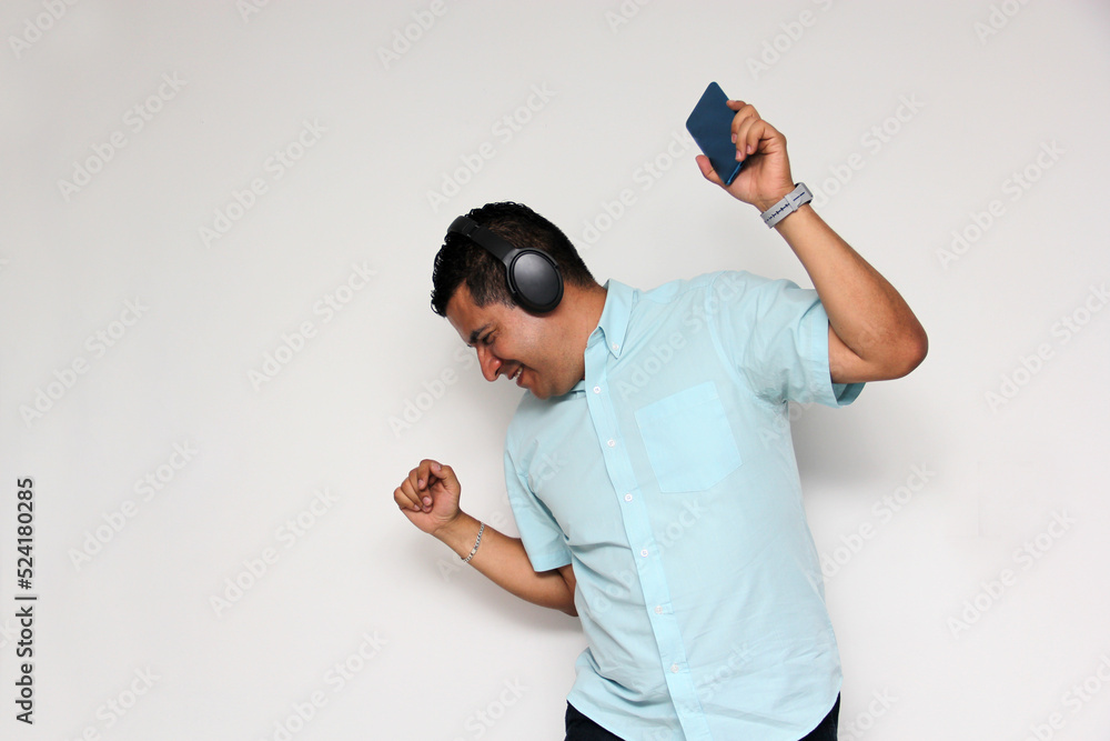 Latin adult man uses his wireless headphones and cell phone to listen to music, dance, relax and enjoy technology
Latin adult man uses his wireless headphones and cell phone to listen to music, dance, relax and enjoy technology