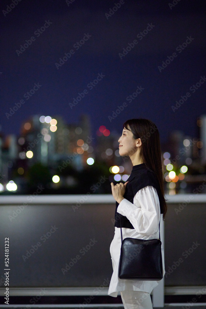 Fototapeta premium 夜の市街地とビジネスウーマン