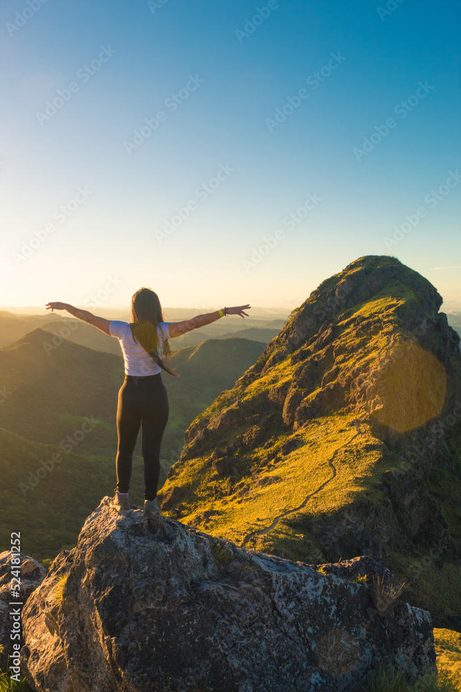 hikeer girl looking to the green mountains in a sunny morning