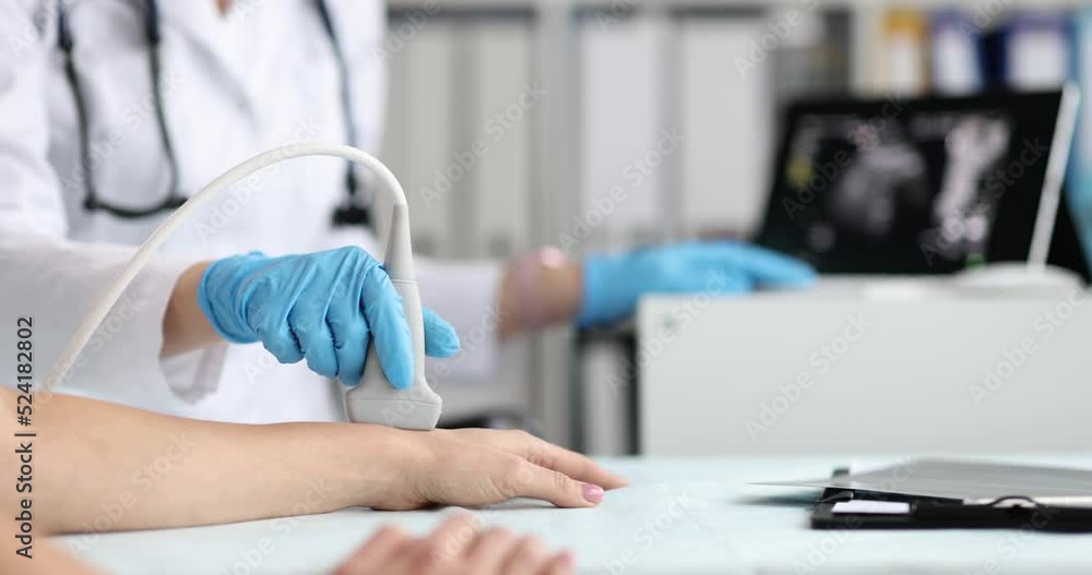 Ultrasound technician examines wrist and hand bones of young woman Ultrasound technician examines wrist and hand bones of young woman