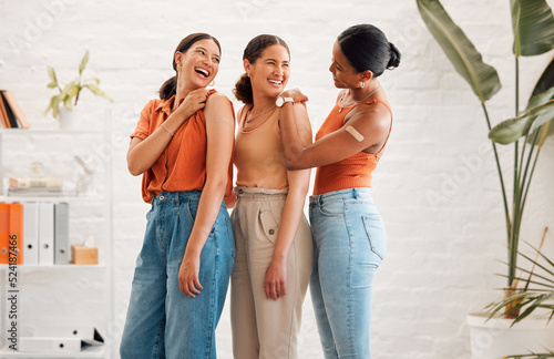 Female friends after receiving covid vaccine, happy and smiling, approving the immunity injection showing bandaid plaster arms. Diverse women recommend booster jab for protection from corona virus.