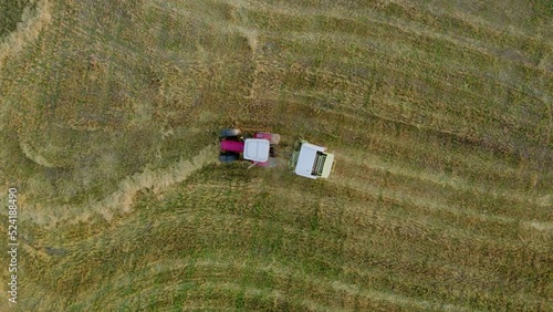 Plunge. Lithuania - 17 August 2022: Baler wrapper working on the  field. View from top.