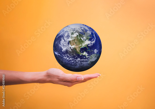Woman hand holding flying earth global isolated on yellow backgrounds  save and earth day concept  Elements of this image furnished by NASA.