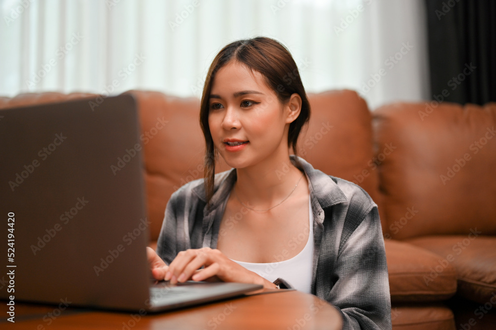 Beautiful Asian female college student using her laptop computer to manage her online homework. Beautiful Asian female college student using her laptop computer to manage her online homework.