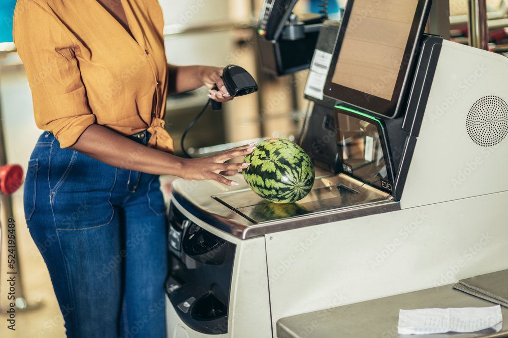 African American Woman buying food at grocery store or supermarket self-checkout - obrazy, fototapety, plakaty 