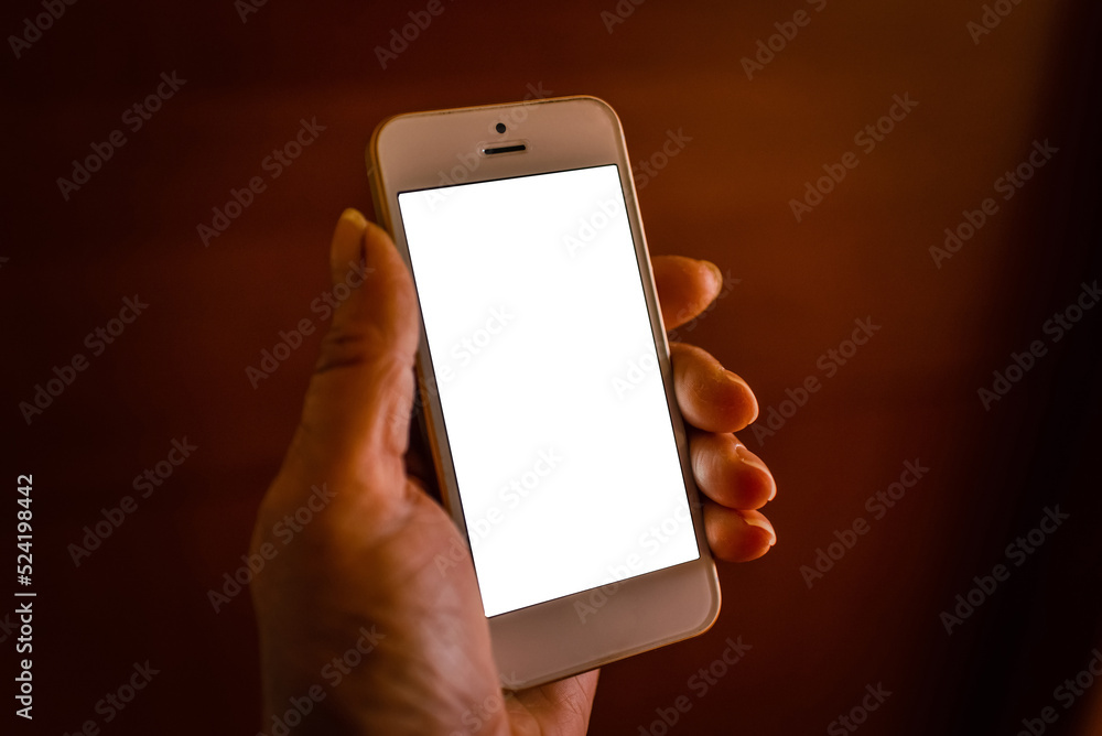 Mobile video.Online connection.Digital mockup.Unrecognizable woman holding smartphone with blank screen at dark room.
