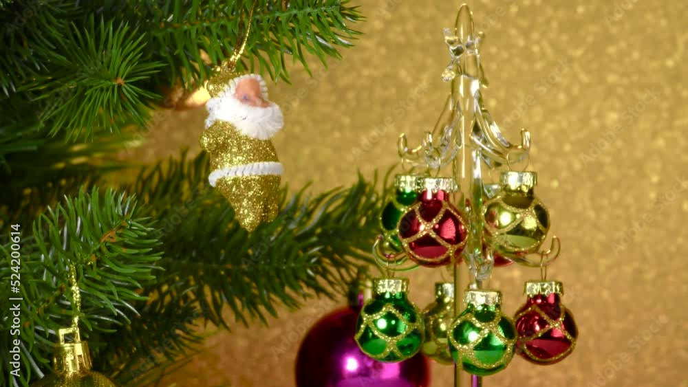 A small Christmas tree rotates near a large decorated Christmas tree A small Christmas tree rotates near a large decorated Christmas tree