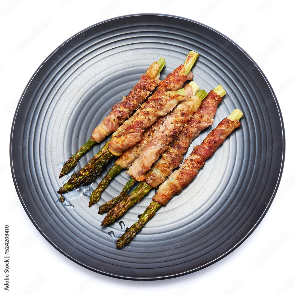 baked aspargus covered with bacon on ceramic plate isolated on white background