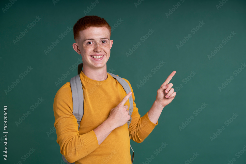 Red head caucasian  teenage boy pointing on copy space