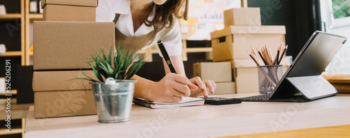 Portrait of Starting small businesses SME owners, two Asian woman check online orders Selling products working with boxs freelance work at home office, sme business online small medium enterprise
