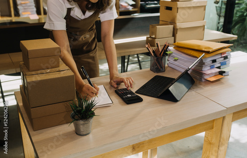 Portrait of Starting small businesses SME owners, two Asian woman check online orders Selling products working with boxs freelance work at home office, sme business online small medium enterprise