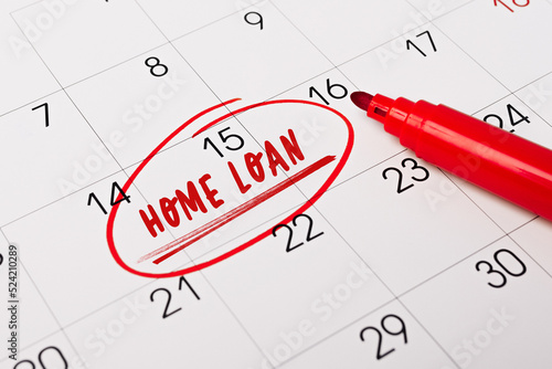 15th day of month marked with red circle. The phrase Home loan written in red text on a calendar page as a reminder. Closeup of a personal agenda, side view. Motivational advice