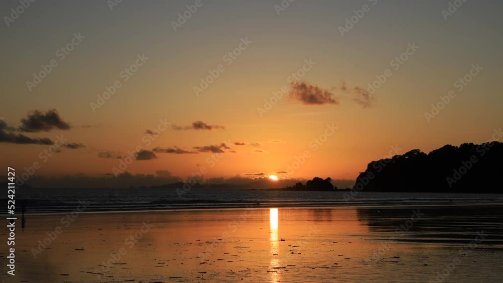 Timelapse 4K of Sunset reflected on wet beach sand with ocean waves and peoples walking on the beach Timelapse 4K of Sunset reflected on wet beach sand with ocean waves and peoples walking on the beach