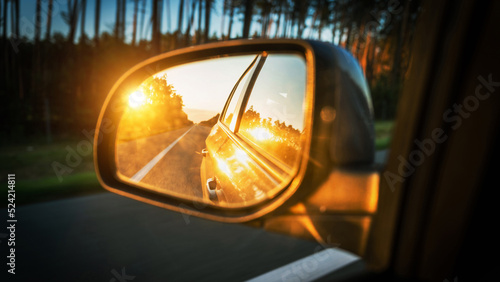 Trip sunset car mirror. Sun, highway car road reflection in mirror. Summer holidays trip concept.