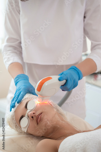 Skin Care Concept. Female During Facial Beauty Laser Treatment While Removing Pigmentation at Cosmetic Clinic Using Intense Pulsed Light Therapy