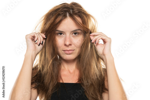 portrait of a young woman with messy long hair on a white background