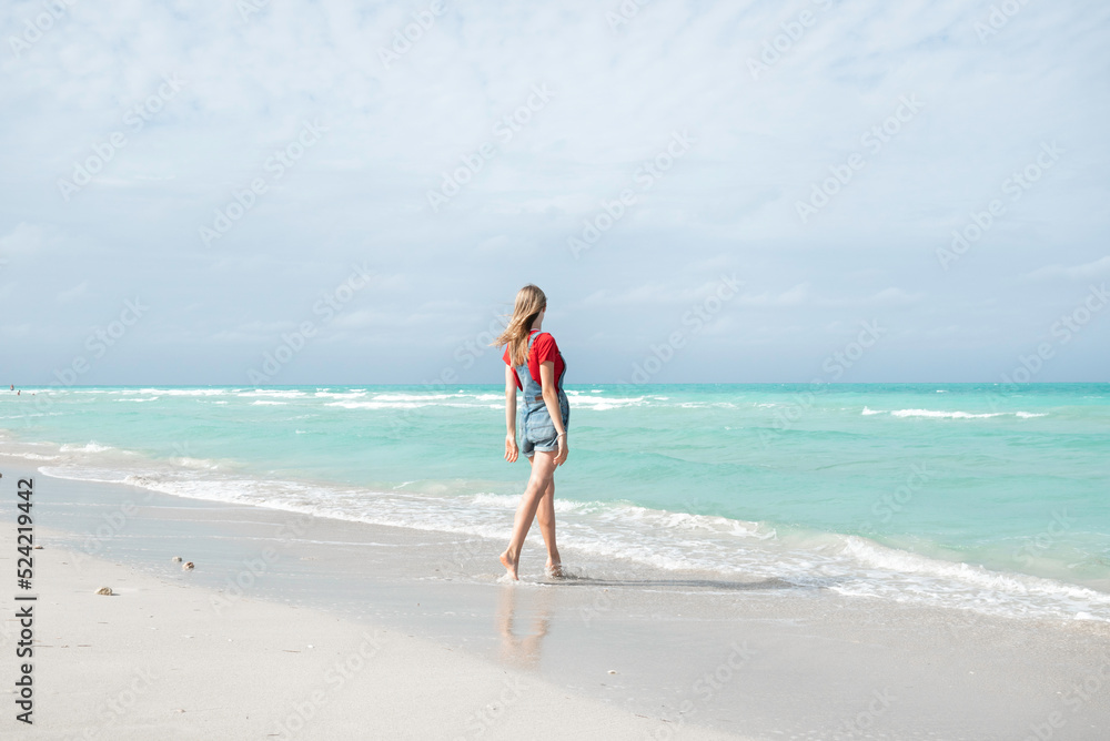 Beautiful young woman walking on the beach Varadero , Cuba Beautiful young woman walking on the beach Varadero , Cuba