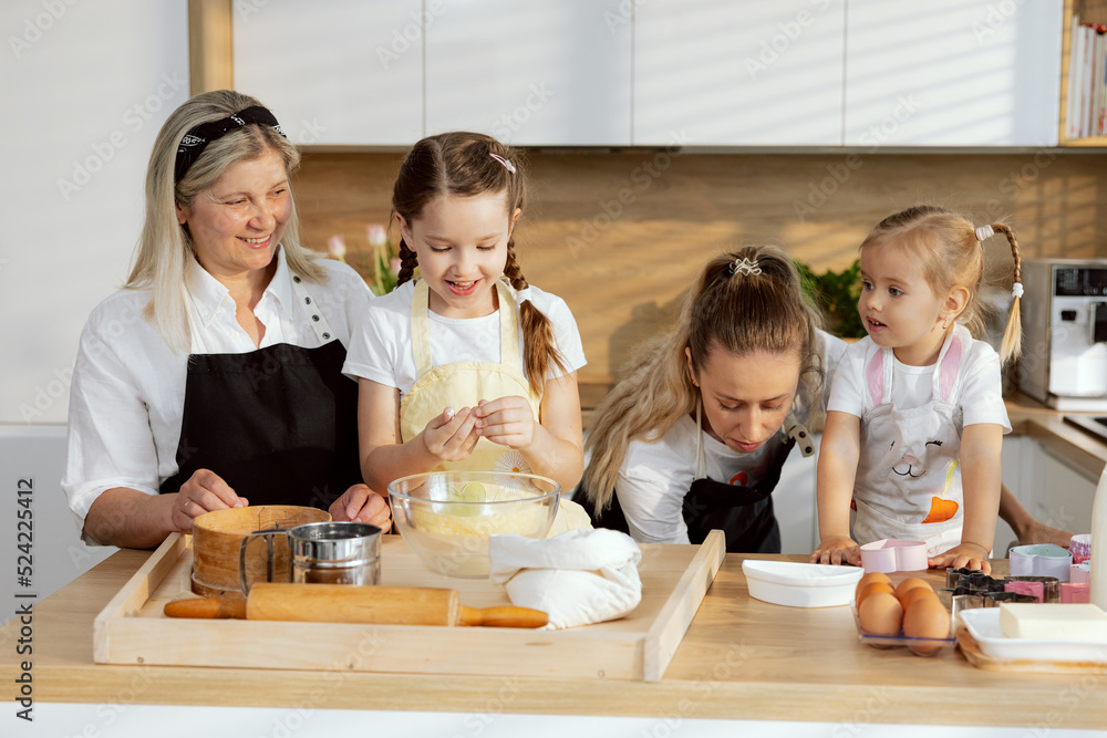 Eldest daughter molds dough mother is looking for vessel for baking grandmother wathcing process preschooler daughter managing process. Women delighted spending time in the kitchen Eldest daughter molds dough mother is looking for vessel for baking grandmother wathcing process preschooler daughter managing process. Women delighted spending time in the kitchen