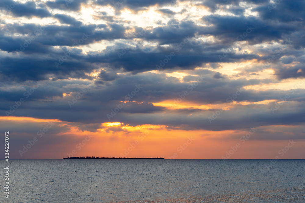 cloudscape over this calm tranquil ocean with clouded sky and sunlight