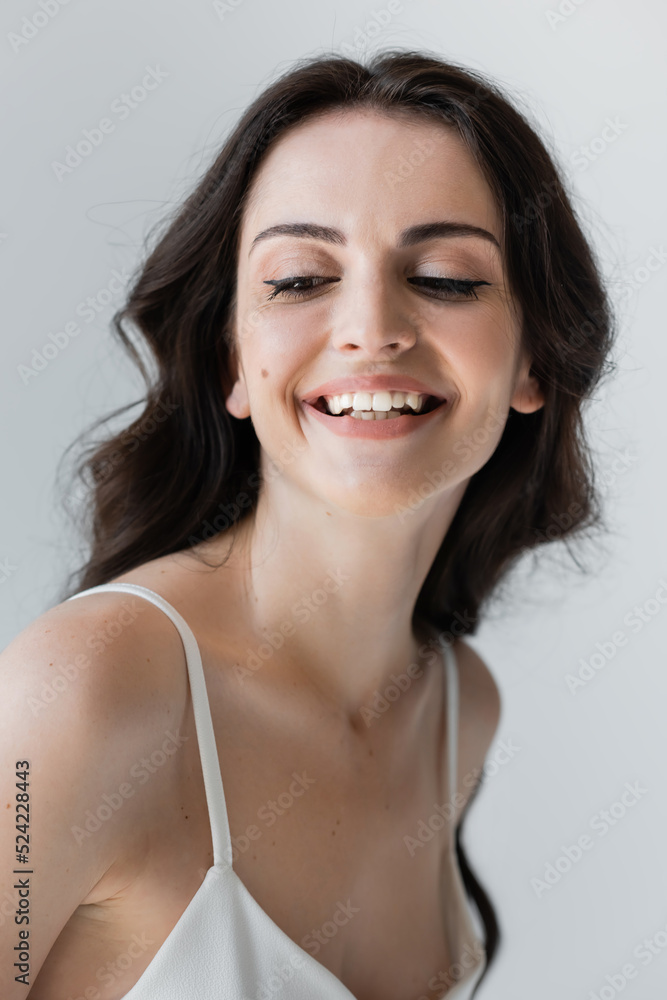 Smiling woman with makeup looking away isolated on grey. Smiling woman with makeup looking away isolated on grey.