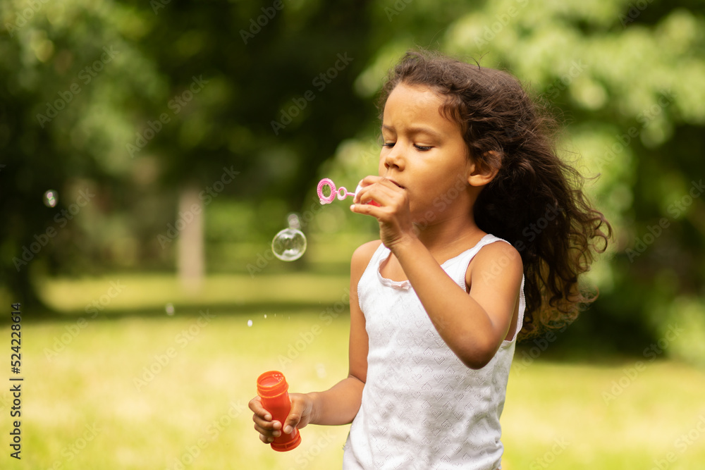 happy african american child outdoor, girl blowing bubbles happy african american child outdoor, girl blowing bubbles