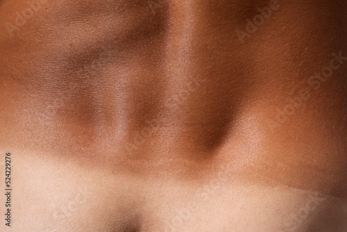 Tanned skin macro detail texture, lower back male body close up, tan line
