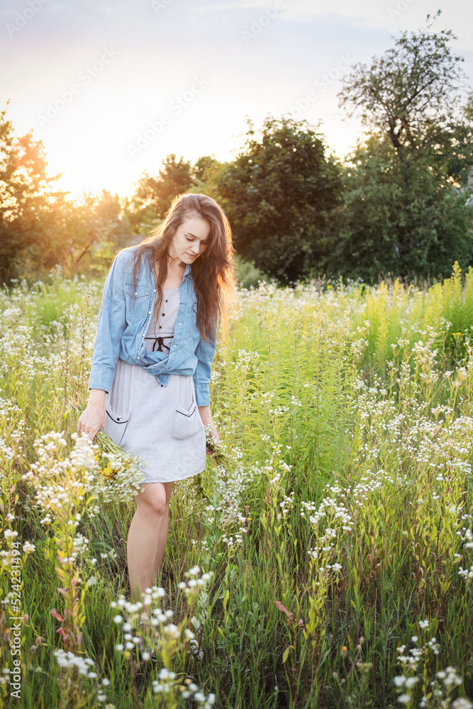 Beautiful girl walking on field on summer with wildflowers. Beautiful girl walking on field on summer with wildflowers.