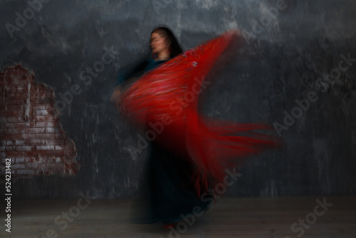 Young adult spanish woman dancing flamenco on gray vintage studio background