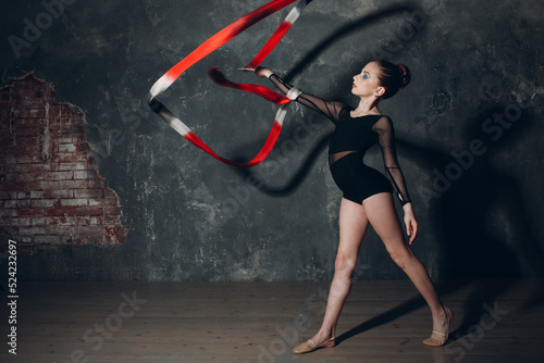 Young girl professional gymnast woman dance rhythmic gymnastics with ribbon at studio.
