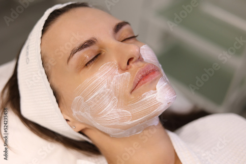 Close up of young clean woman face with cream with anesthesia.  Patient's face macro.  Biorevitalization or thread lifting procedure. Portrait of woman in beauty clinic with doctor beautician.