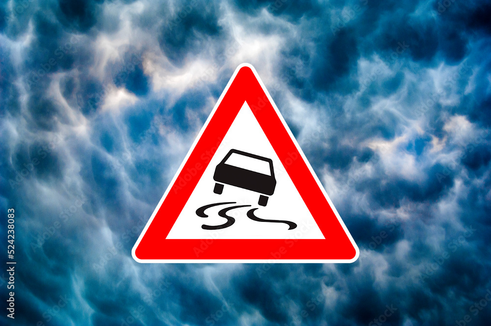 Ein dreieckiges Piktogramm mit Gefahrenhinweis vor dramatsichem Himmel Ein dreieckiges Piktogramm mit Gefahrenhinweis vor dramatsichem Himmel