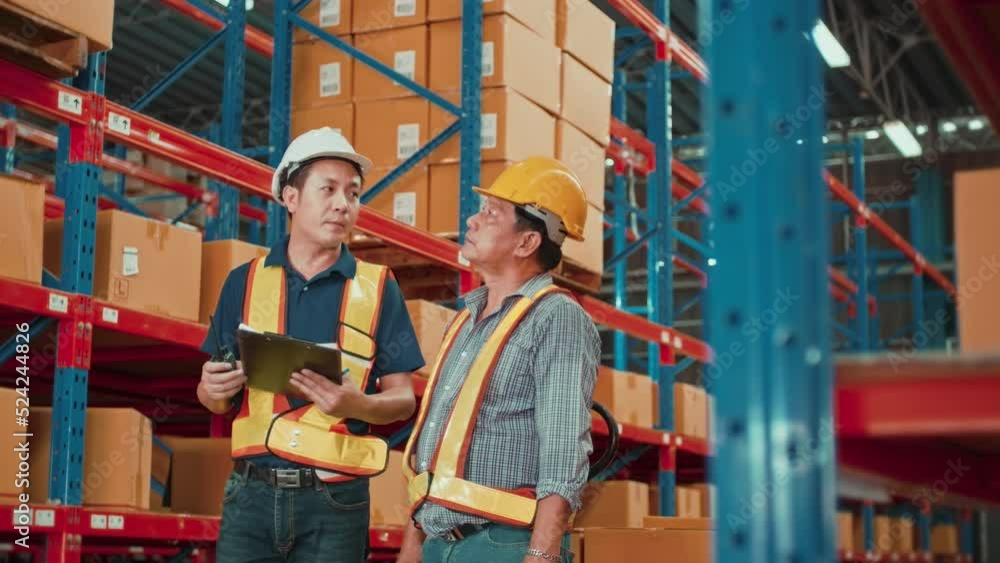 Group of workers wearing helmet checking inventory and discussing in modern warehouse. Group of workers wearing helmet checking inventory and discussing in modern warehouse.