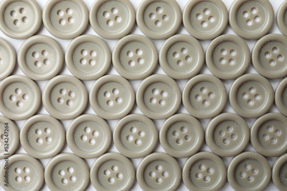 Many grey sewing buttons on white background, closeup Many grey sewing buttons on white background, closeup