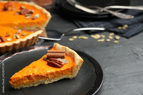 Slice of delicious homemade pumpkin pie on black table