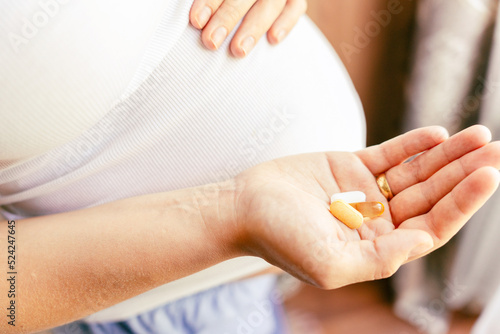 Pregnant medication vitamin pill. Happy young pregnant woman holding supplement vitamin pill. Diet nutrition. Healthy eating, lifestyle.