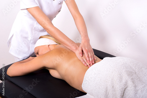 Young woman getting massage therapy in massage salon