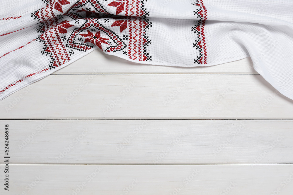 Fotografie Beautiful rushnyk on white wooden table, top view with space for text