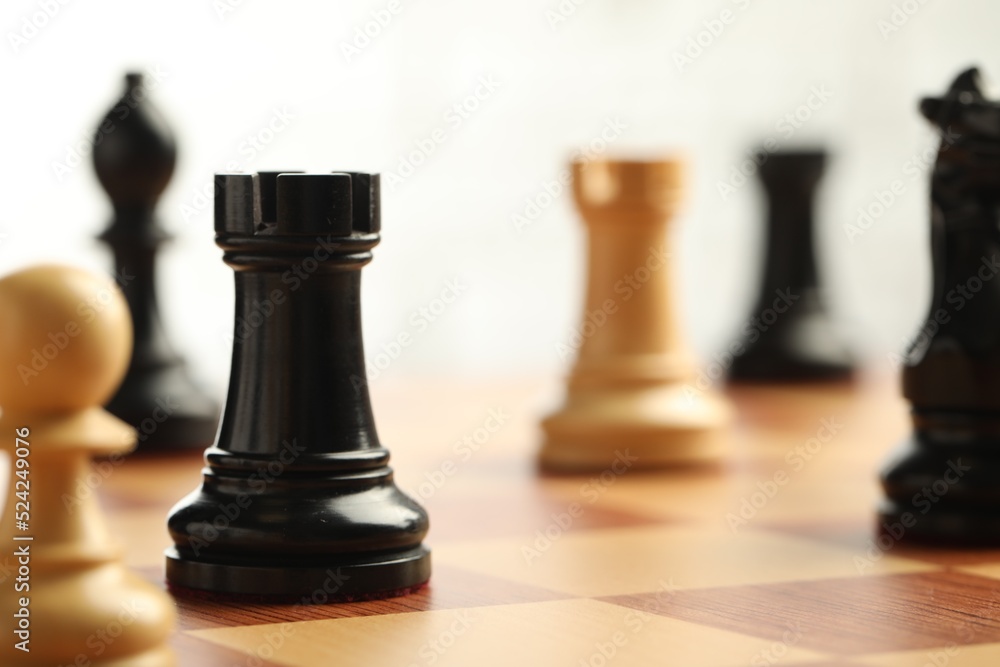 Chessboard with game pieces on light background, closeup. Space for text Chessboard with game pieces on light background, closeup. Space for text