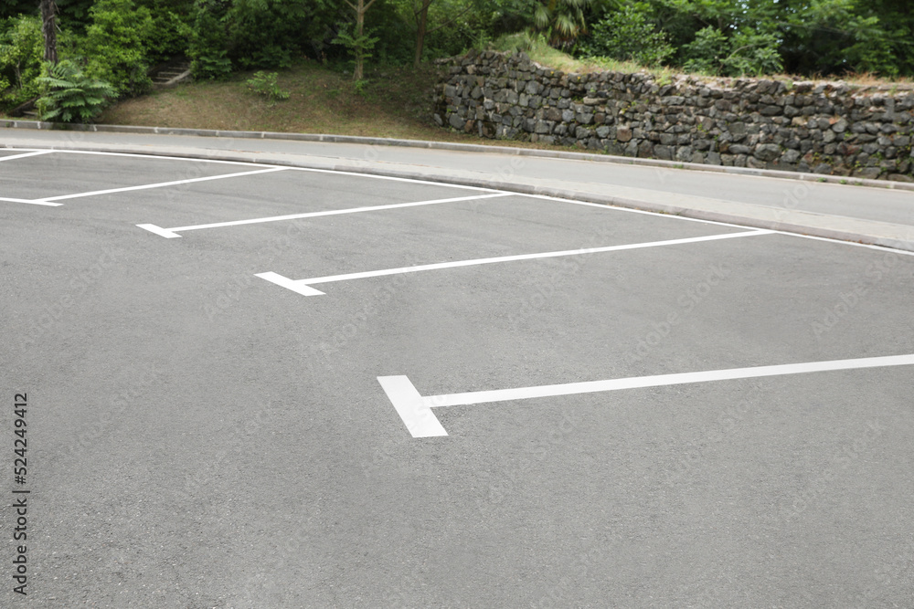 Obraz premium Empty outdoor parking lot with painted markings on asphalt