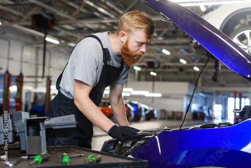 A car service worker during the work on replacing filters and oil in the car engine. Professional service station © makedonski2015