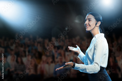 Motivational speaker with headset performing on stage photo